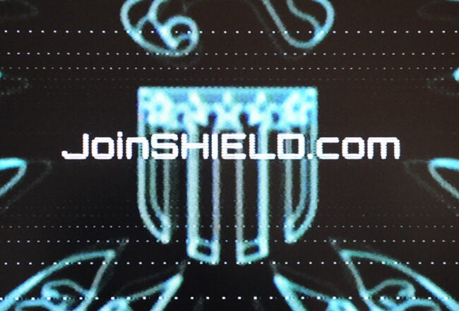 Futuristic blue and black design featuring text "JoinSHIELD.com" with a stylized shield emblem, suggesting a promotional or recruitment theme.