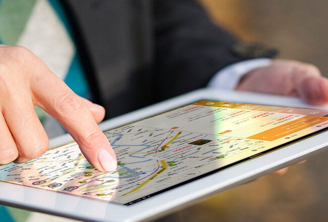 Person using a tablet with a map application open, showing navigation or route finding.