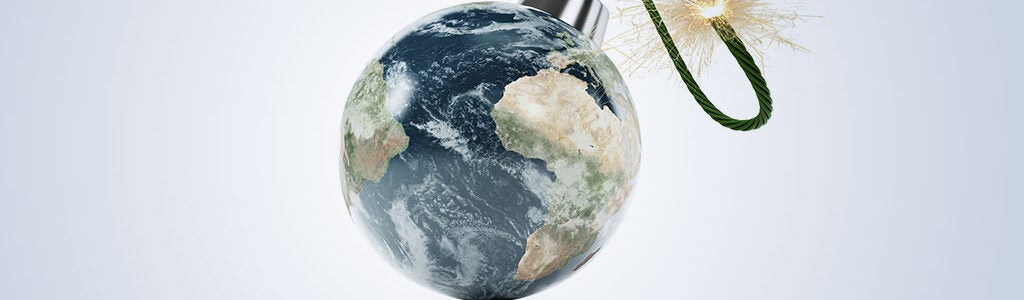 The image depicts Earth as a spherical bomb with a lit fuse, symbolizing global tension or environmental crisis.