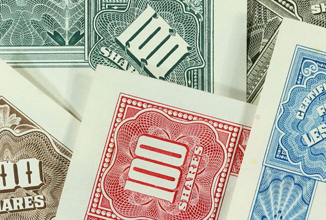 Various vintage stock certificates in different colors, each prominently displaying "100 Shares" or "Certificate for Less Than 100."