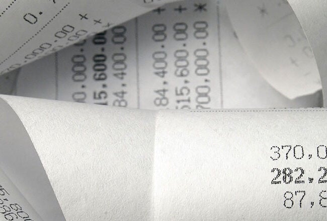 Rolled-up paper receipts with numerical figures, likely representing financial transactions or calculations.