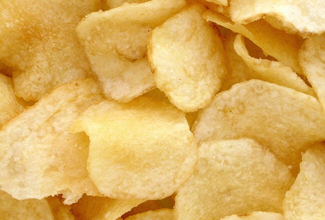 A close-up view of several golden, crispy potato chips. The image showcases their texture and appetizing appearance.