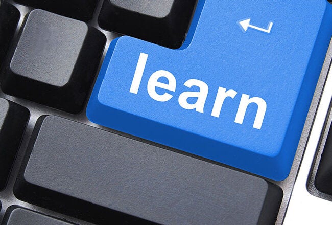 A computer keyboard with a large blue key labeled "learn," replacing the usual Enter key. This represents online learning or education.