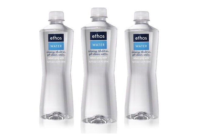 Three clear plastic bottles of Ethos Water with blue labels.