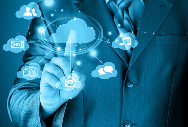 A person in a suit interacting with a digital cloud interface, featuring icons representing social networking, music, photos, and communication.