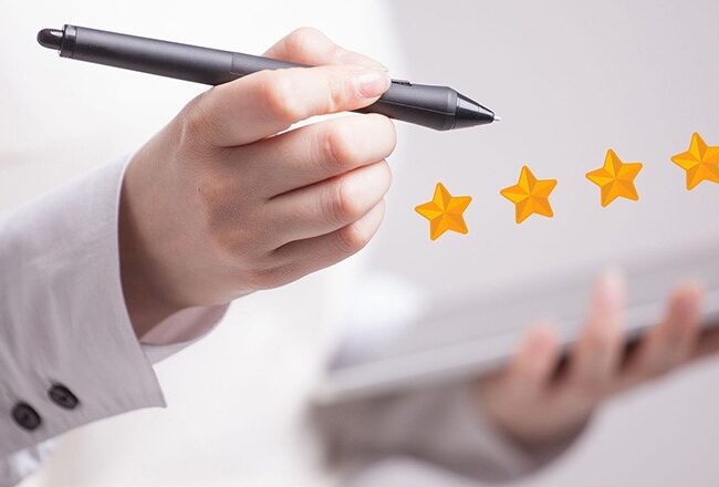 A person holding a stylus over a tablet, with five gold stars displayed, representing a five-star rating or positive review.