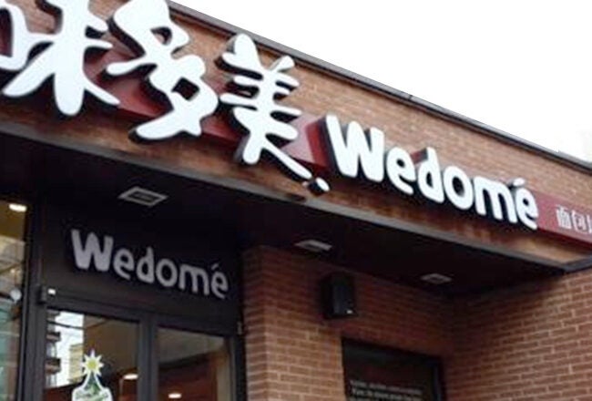 A storefront with signage displaying "Wedome" and Chinese characters on a brick building.