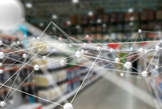 A retail store interior with blurred aisles and shelves, overlaid with a white network of connected nodes, symbolizing data connectivity or technology integration in retail.