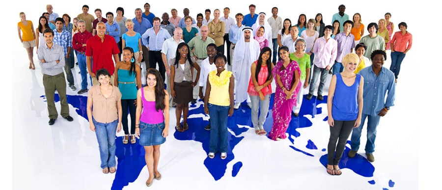 A diverse group of people standing on a map, symbolizing global unity and multiculturalism.