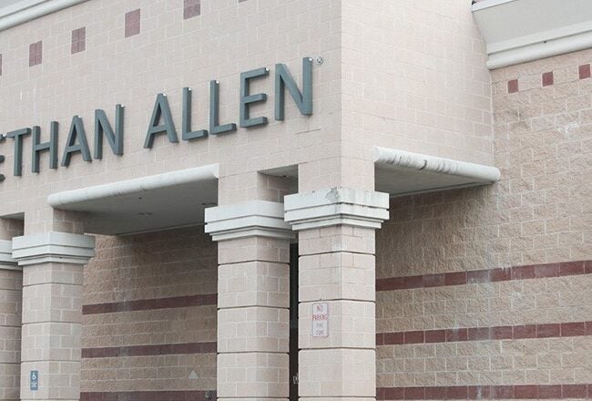 Storefront of Ethan Allen, featuring a brick exterior with large signage above the entrance.