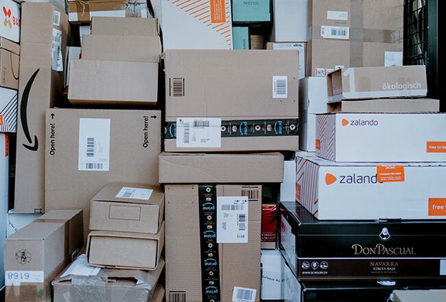 A large stack of cardboard boxes of various sizes, including some with visible brand labels like Zalando and Don Pascual.