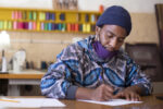 An African Man Sketching A Design In His Fashion Design Studio In Kayamandi South Africa.
