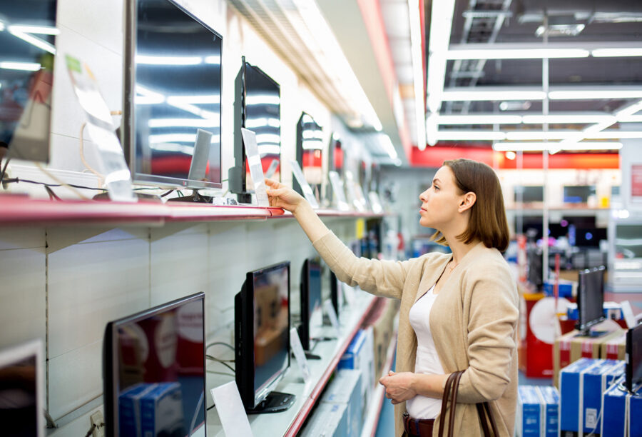 Woman shopping for TVs at a category killer store
