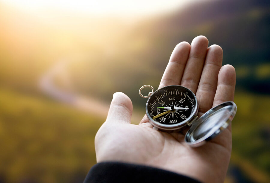 Hand holding a compass outside to show brand purpose and consumer trust