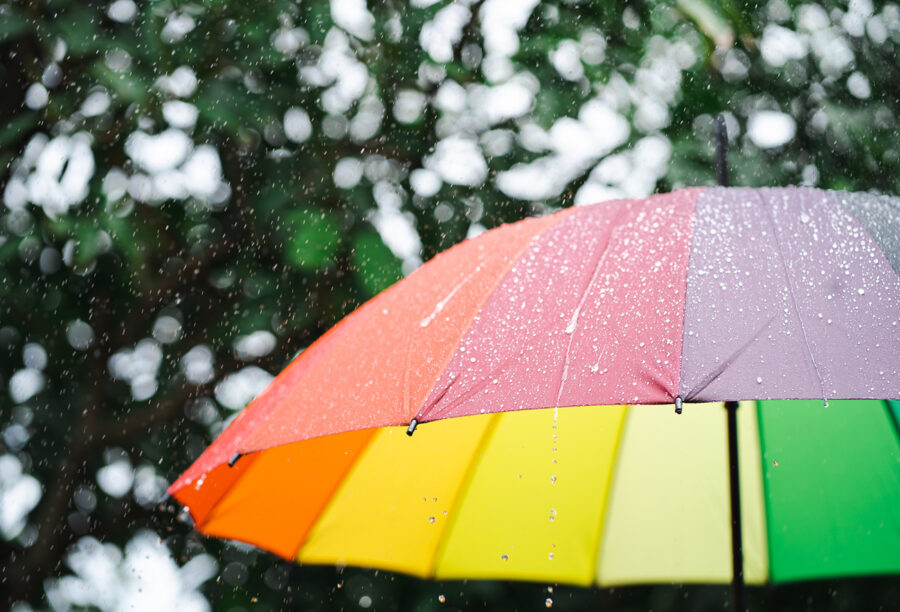 Rainbow umbrella blocking the rain to symbolize resilient marketing