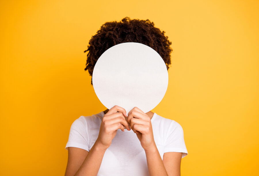 Woman of color covering her face with a blank circle