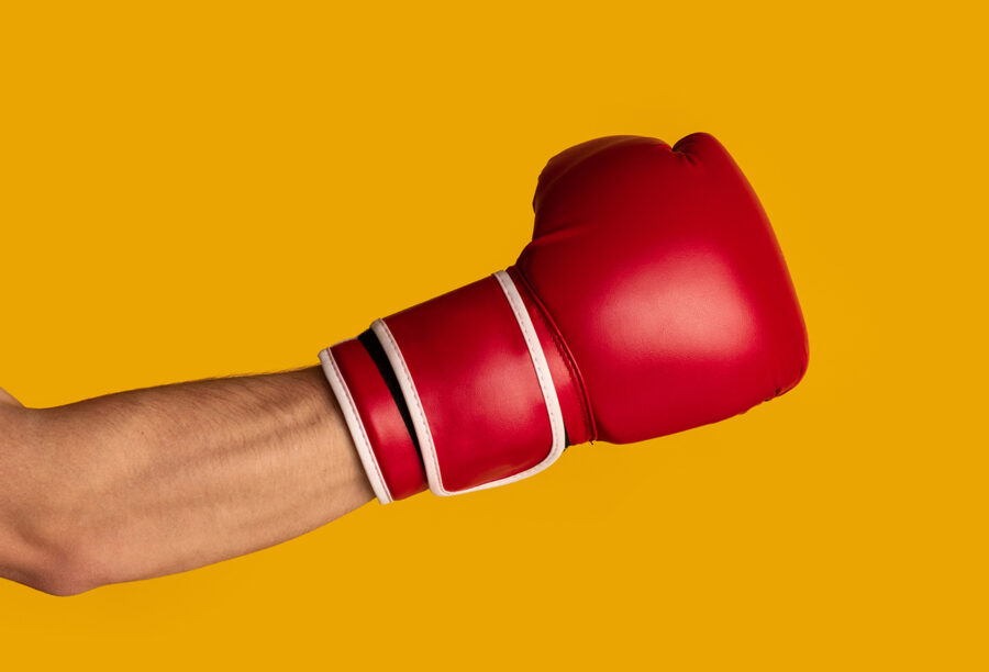 Closeup of an arm wearing a boxing glove to illustrate negative advertising. Are attack ads effective?