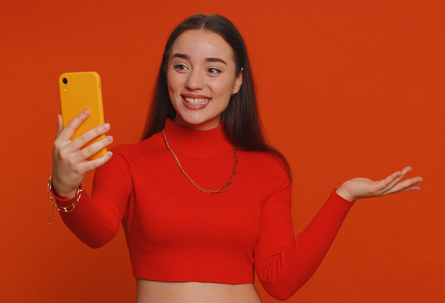 Influencer smiling as she films something for a marketing campaign on her phone