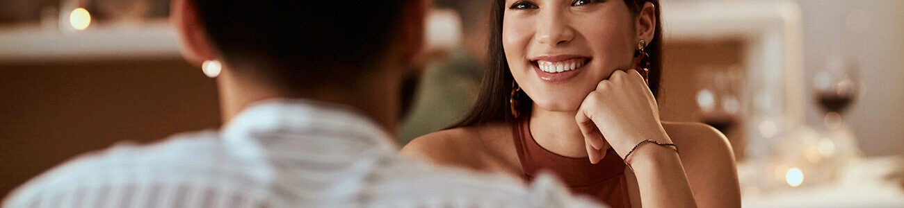 Woman smiling at her date at a fancy restaurant. How did an experiment in speed dating shed light on AI trust?