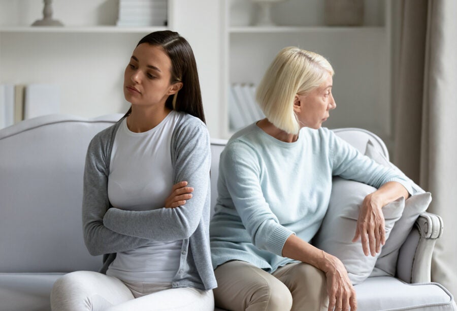 A younger and older woman facing away from each other on the couch to show the overlooked issue of reverse ageism