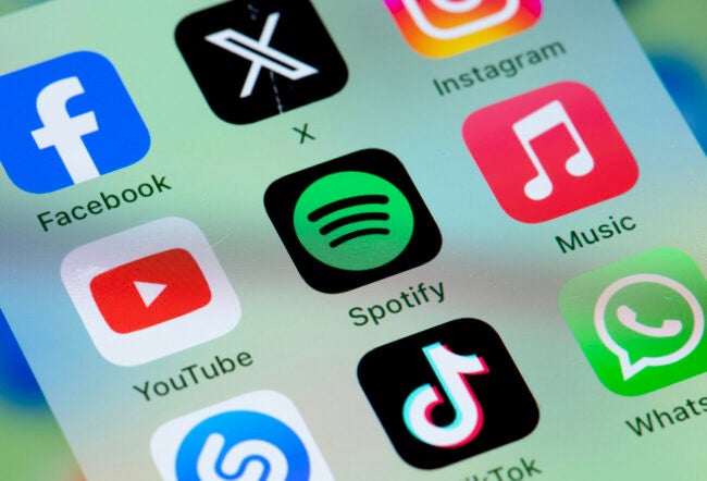 Spotify and other apps on a phone screen to show how digital platforms turn rivals into allies