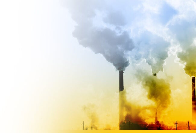 Industrial chimneys emitting large clouds of smoke into the sky, symbolizing pollution and environmental impact. The image has a gradient effect from warm tones to cooler ones.