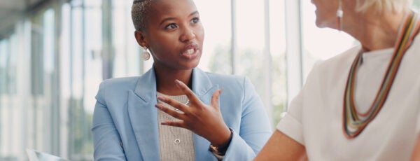 Junior employee speaking with her manager during a work evaluation.