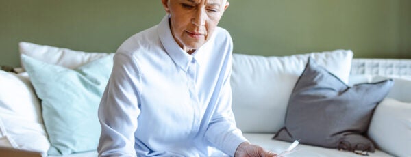 A senior woman sitting in her living room calculating social security taxes