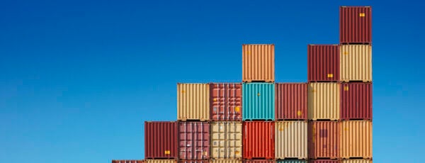 Colorful shipping containers stacked on top of each other in front of a blue background