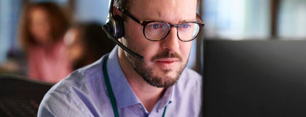 Call center employee staring at a computer screen with concern