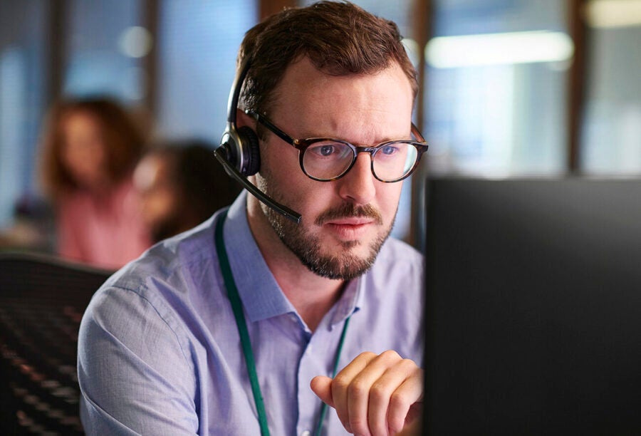 Call center employee staring at a computer screen with concern