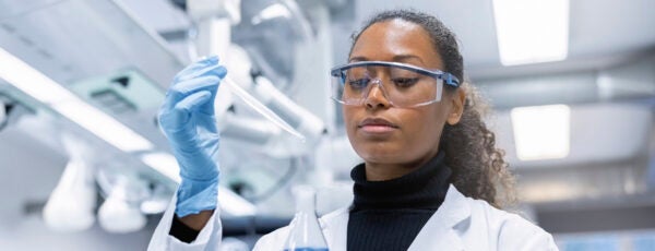 Woman scientist experimenting with chemicals in lab.