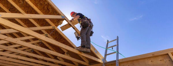 Construction worker building the roof of a house