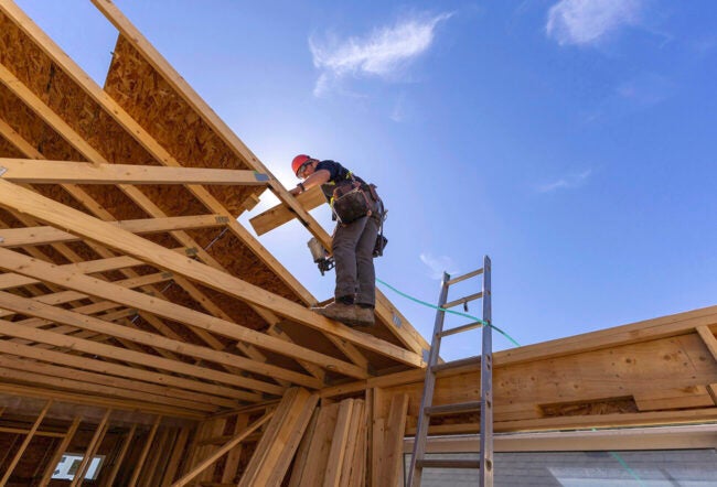 Construction worker building the roof of a house