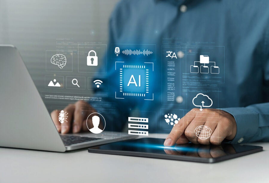 A person interacts with a tablet displaying digital icons related to artificial intelligence and technology, including a brain, padlock, and cloud symbols.