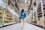 Woman walking down the aisle of a big box store