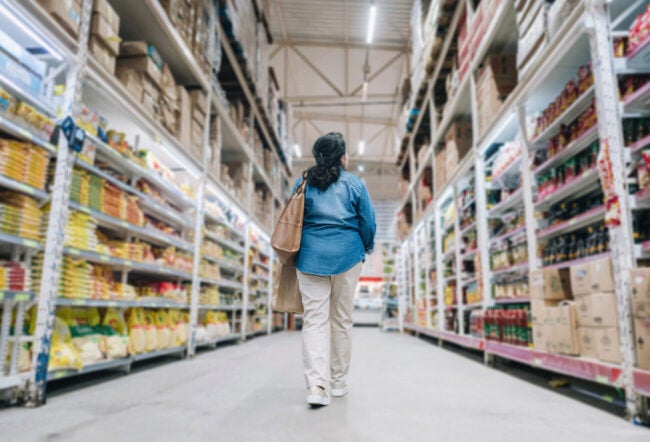 Woman walking down the aisle of a big box store
