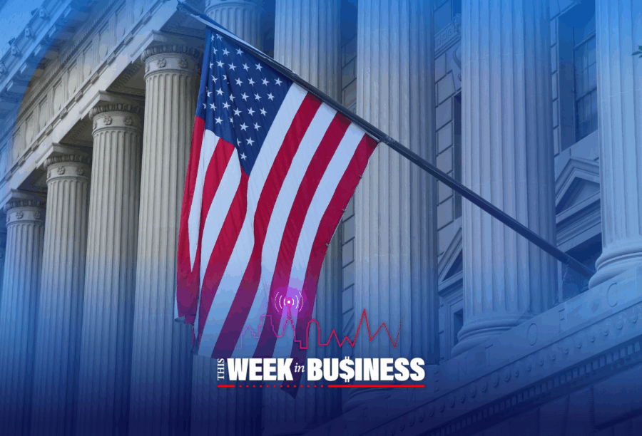 The image shows the U.S. flag in front of a classical building with columns. Overlay text reads, "This Week in Business" with a city skyline and graph line.