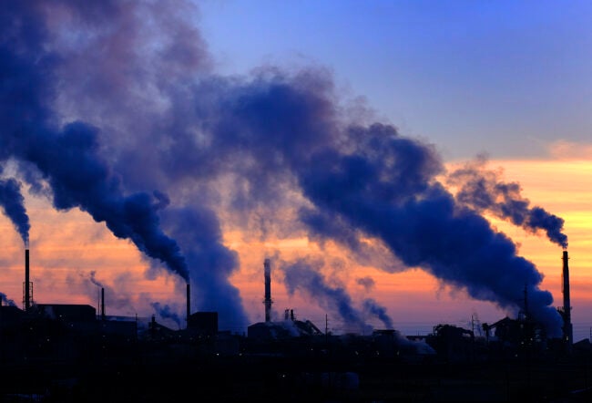 Dark smoke coming out of factory pipes in the distance