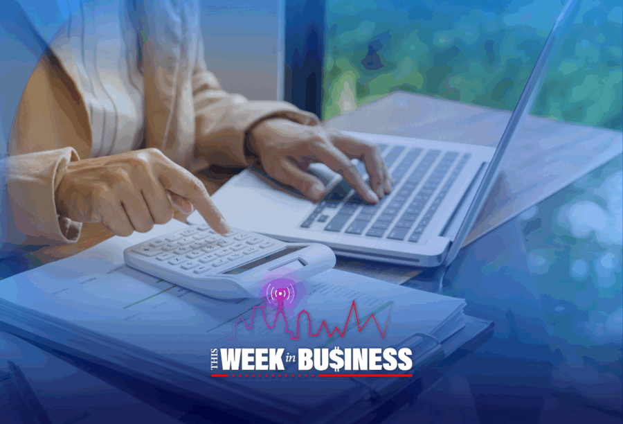 Person using a calculator and laptop with "This Week in Business" graphic overlay.