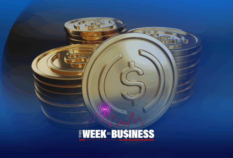 Stacks of gold coins with a dollar sign embossed on each. In the foreground, the text "This Week in Business" with a city skyline and audio wave icon.