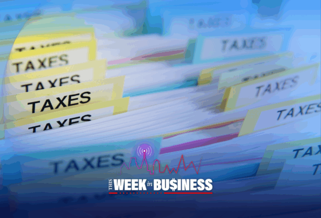 Folders labeled "TAXES" organized in a row, suggesting paperwork or files related to taxes. The image represents financial documentation or tax management.