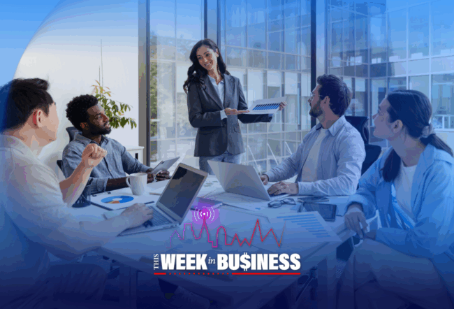 A business meeting with a diverse group of people seated around a conference table, engaging in discussion. Laptops and documents are visible. The text "This Week in Business" is displayed at the bottom.